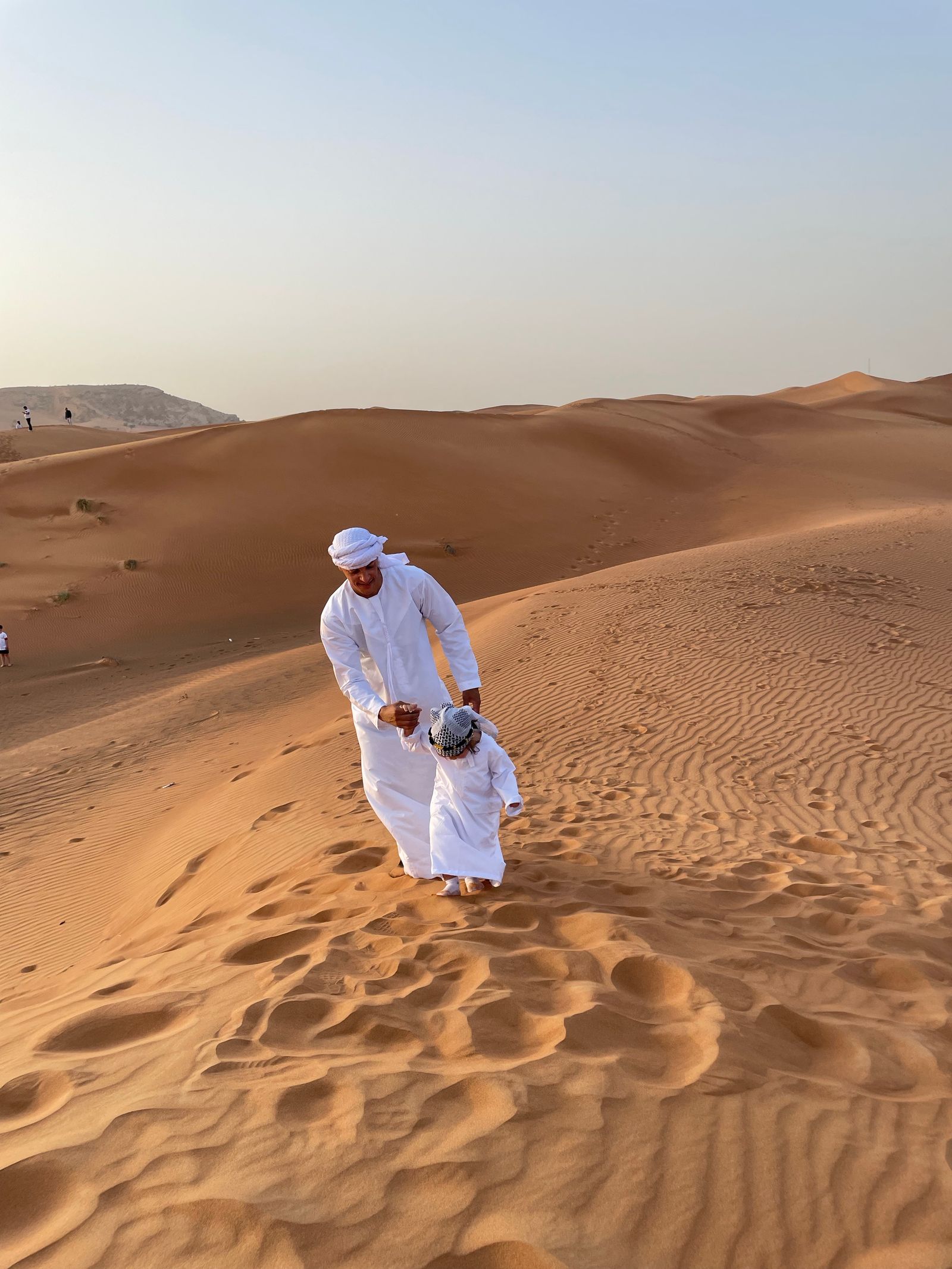 أب وطفل فوق كثبان رملية في الإمارات